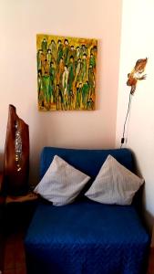 a blue couch in a room with a painting on the wall at Appartement Lona, El Cieno mit Pool direkt am Meer in Valle Gran Rey