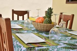 stół z tkaniną stołową z koszem ananasów w obiekcie Akwa Guesthouse Cotonou w mieście Kotonu