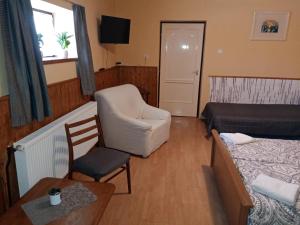 Zimmer mit einem Schlafzimmer mit einem Bett und einem Stuhl in der Unterkunft Véndektanya Vendégház in Tapolca