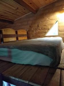 1 cama en una cabaña de madera con ventana en Chalés Savi, en Vale do Capao