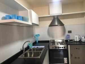 a kitchen with a sink and a stove at Arenas- Departamento de playa in Puerto Madryn