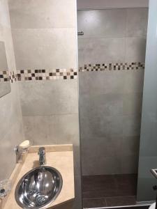 a bathroom with a sink and a shower at Arenas- Departamento de playa in Puerto Madryn