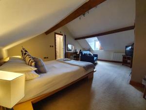 a bedroom with a large bed and a living room at Ty Morgan's in Rhayader