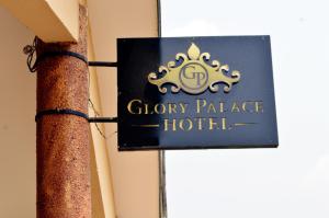 un panneau indiquant un hôtel de palais en argile sur un poteau dans l'établissement Glory Palace Hotel, à Cotonou