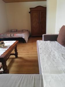 Sala de estar con 2 camas y mesa en Appartement 60m2 entre lac et montagne, en Vailly