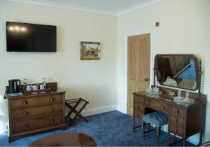 a living room with a dresser and a mirror at The Royal in Barmouth