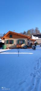 una casa con mucha nieve delante de ella en Haus am Mühlenberg, en Deetz