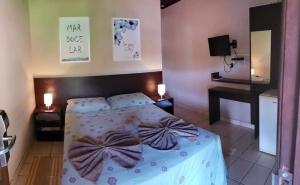 a bedroom with a bed with bows on it at Vento Sul in Abraão