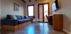 a living room with a blue couch and a table at Andros 4 All Seasons Villas & Suites in Andros