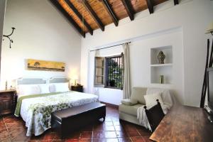 Un dormitorio con una cama, un sofá y una mesa. en Hotel Fuente del Sol, en Antequera