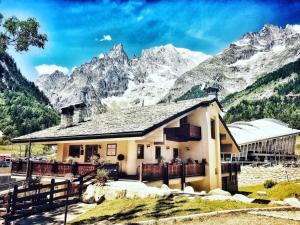 a house with mountains in the background at Shatush Hotel in Courmayeur