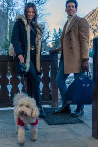 a woman and a man standing next to a small dog at Shatush Hotel in Courmayeur