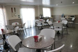 Hoteles Bogotá Inn Lago Chico في بوغوتا: غرفة طعام مع طاولات وكراسي بيضاء