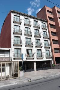 a white building with balconies on a street at Hoteles Bogotá Inn Lago Chico in Bogotá