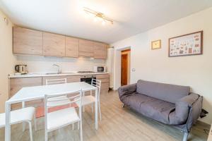 cocina y sala de estar con mesa y sofá. en Appartamento Dei Pini, en Alleghe