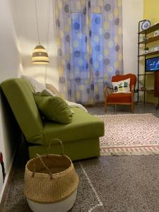 a living room with a green couch and a chair at CASA IVO in Genoa