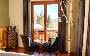 a bedroom with two chairs and a table in front of a window at Berghaus Weissbriach in Weissbriach