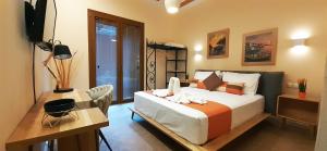 um quarto com uma cama, uma secretária e uma televisão em Andros 4 All Seasons Villas & Suites em Andros