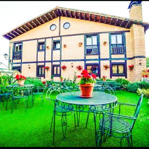 a patio with tables and chairs in front of a building at Posada Real de Carreteros in Casarejos