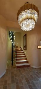 a hallway with a staircase with a chandelier at Andros 4 All Seasons Villas & Suites in Andros