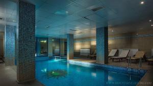 a large swimming pool in a building with chairs and tables at Studio 6,Smolyan lakes in Smolyan