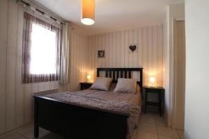een slaapkamer met een bed met 2 nachtkastjes en een raam bij Chalet Changalan in Vars