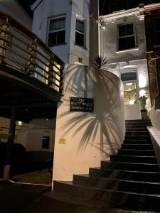 a shadow of a sign on the stairs of a house at The White House Hotel in Newquay