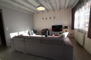 a living room with a couch and a tv at Chalet Changalan in Vars
