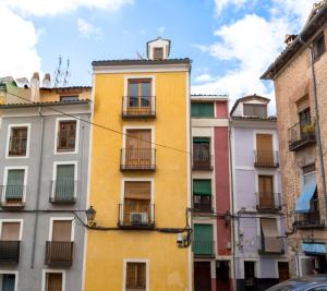 un edificio amarillo con balcones en una calle de la ciudad en Moneda 46, en Cuenca