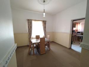 a dining room with a table and a window at Cosmetro Homes Abuja in Abuja