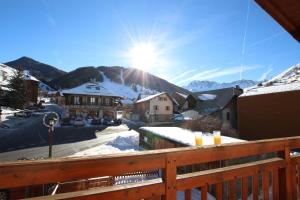 a view from a balcony of a town with snow covered mountains at Chalet Changalan in Vars