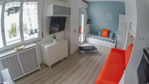 uma sala de estar com um sofá laranja e uma televisão em La Casa di Pamy em Bellaria-Igea Marina