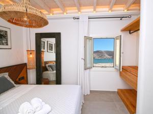 a bedroom with a bed and a view of the ocean at Enalion Suites in Mikonos