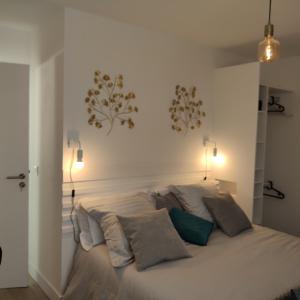 a bedroom with a large white bed with pillows at LE 21 Vue sur Mer in Concarneau