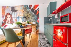 Il comprend une cuisine équipée d'un réfrigérateur rouge et d'une table avec des chaises. dans l'établissement Le Pop Art - Topbnb Dijon, à Dijon