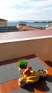 a table with a bowl of fruit and a bowl of nuts at Apartments Amazing Sunset 100m from Sea in Ždrelac