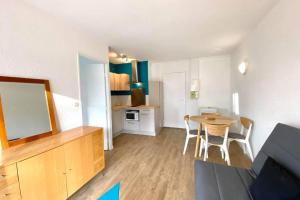 sala de estar con mesa y cocina en Logement 4 lits en plein coeur de Cabourg en Cabourg