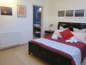a bedroom with a large bed with red and white pillows at Foresteria Conti, sulle tracce di Shakespeare in Padova