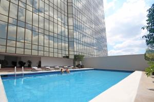 a swimming pool in front of a tall building at Presidente InterContinental Guadalajara, an IHG Hotel in Guadalajara