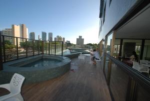 a balcony with a hot tub on top of a building at Ilusion Flat -Natal in Natal