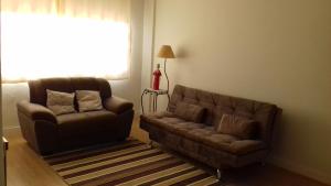 a living room with a couch and a chair at Ótima localização in Águas de Lindoia