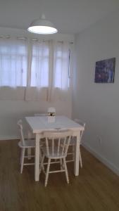 una mesa blanca y sillas en la sala de estar. en Ótima localização en Águas de Lindóia