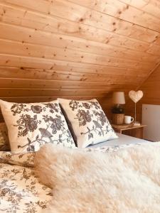 a bedroom with a bed and a wooden ceiling at Drewniany domek nad Miedwiem in Morzyczyn