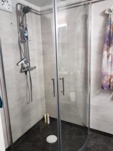 um chuveiro com uma porta de vidro na casa de banho em Nostalgirum em Kil