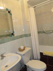 y baño con aseo blanco y lavamanos. en Hotel Baleares en Santiago