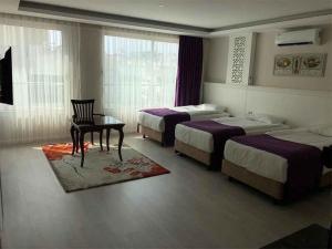 a bedroom with three beds and a table and a chair at Prime Boutique Hotel in Antalya