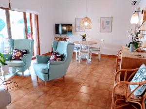 a living room with blue chairs and a table at Marmirada in Sant Lluis