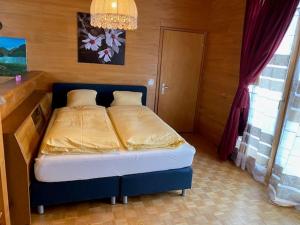 ein kleines Schlafzimmer mit einem Bett mit blauem Rahmen in der Unterkunft Casi in Brienz