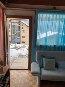 ein Wohnzimmer mit einem Sofa und einer Glasschiebetür in der Unterkunft Casi in Brienz