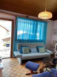 a living room with a couch and a blue curtain at Casi in Brienz